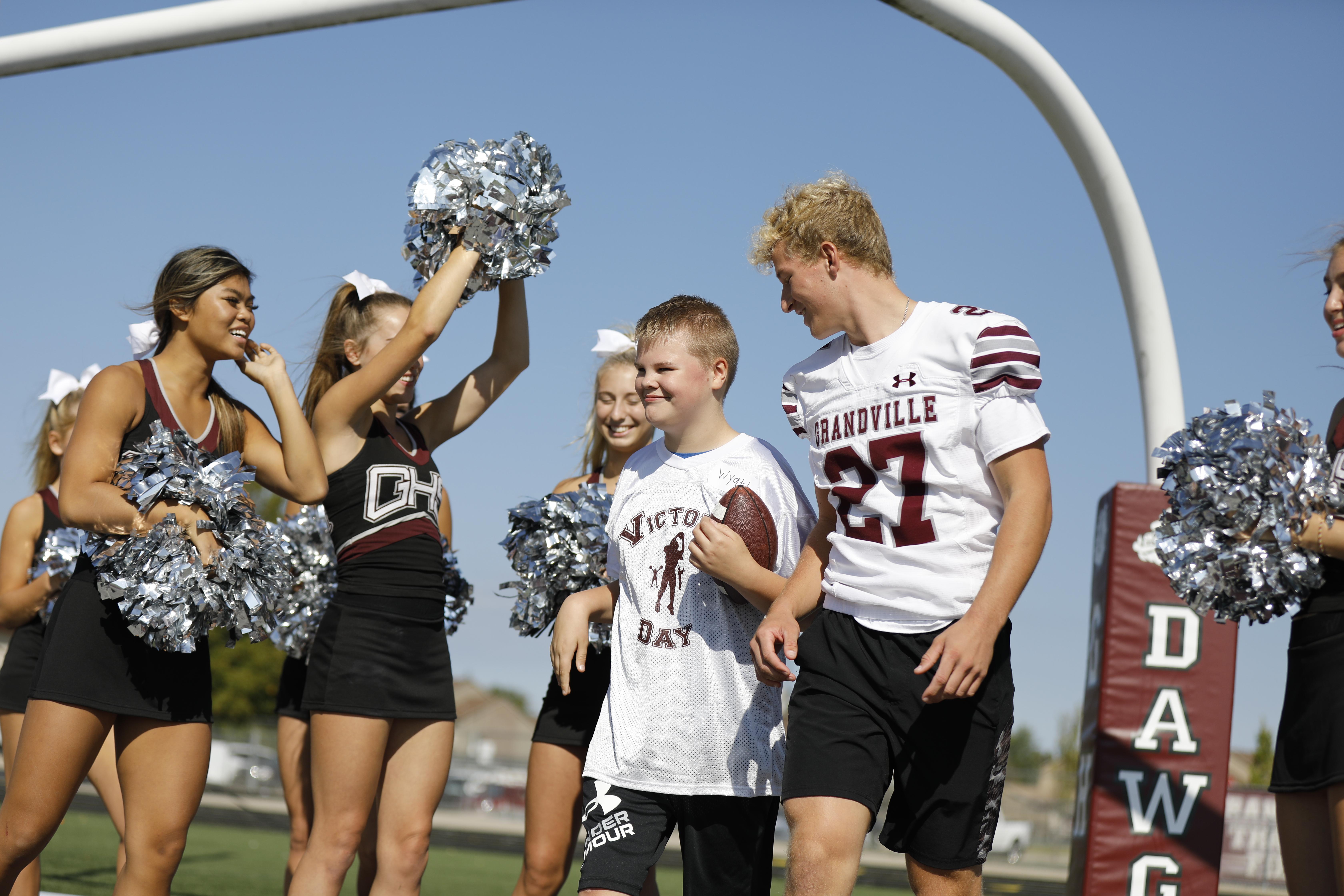 Victory Day participant smiles with cheerleaders